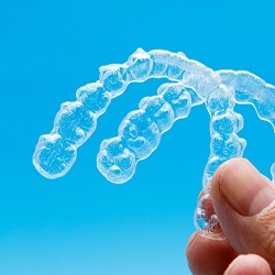 person holding two clear aligners