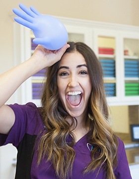 Brooklyn holding inflated glove to forehead