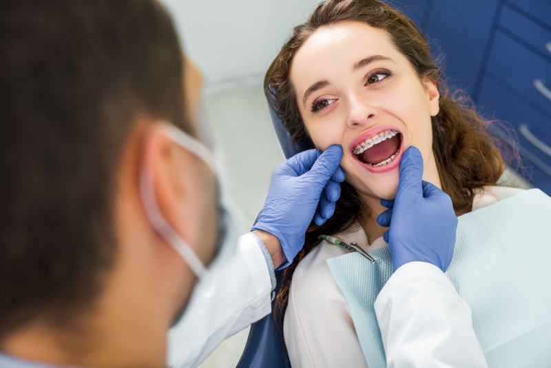Dentist examining patient's braces during appointment